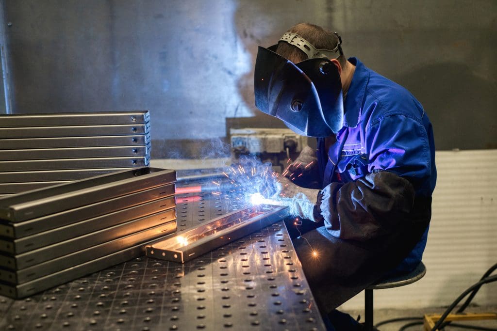 A welder provides finishing touches on a number of metal girders.
