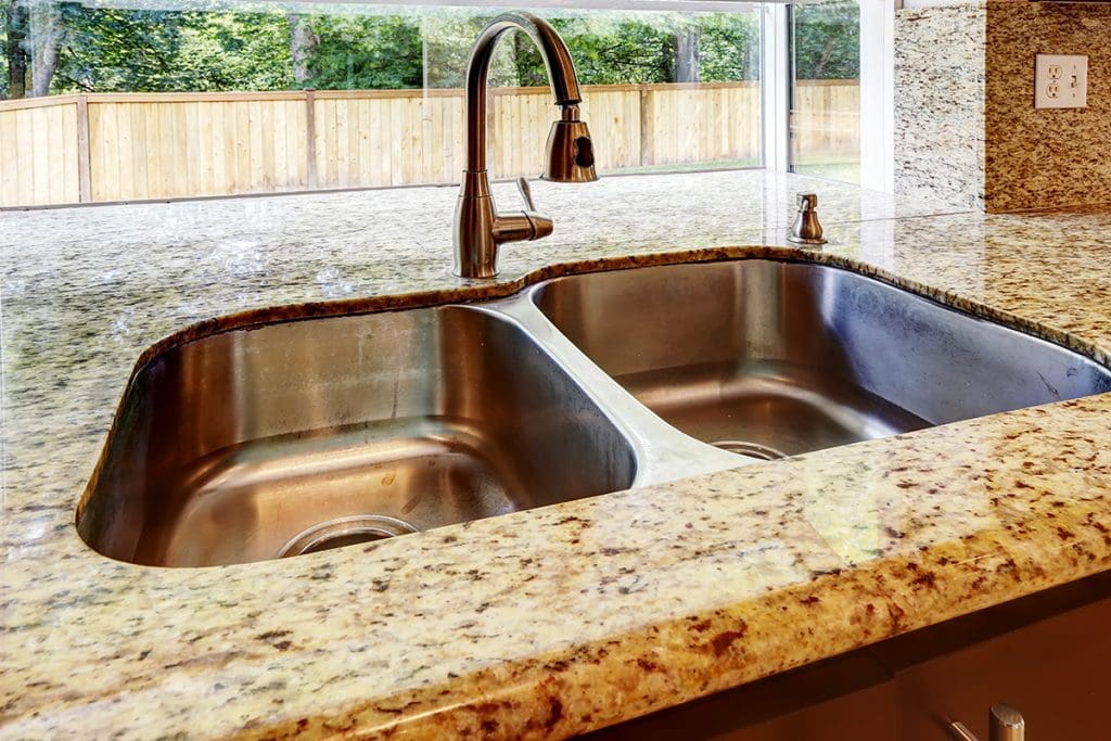 A stainless steel sink set into a granite countertop