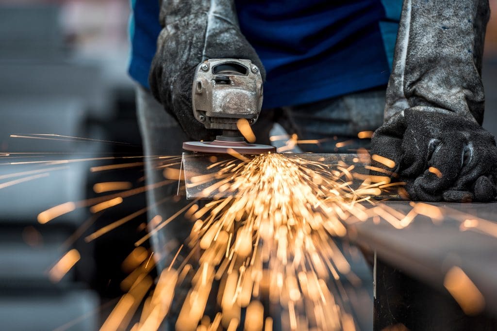 A closeup of a piece of metal being formed with a grinder